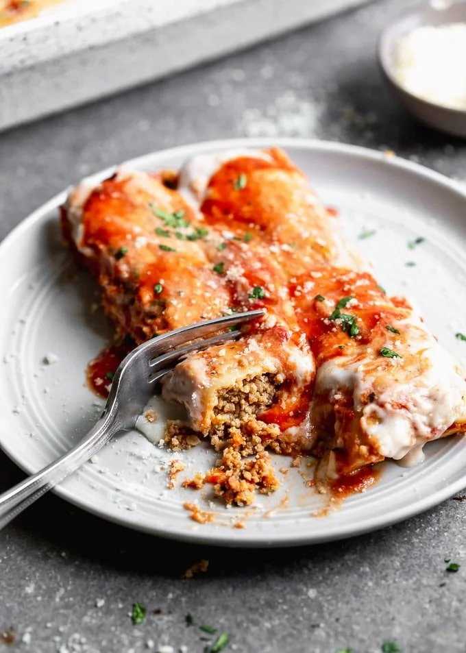This Meat Cannelloni with Creamy Tomato Béchamel has homemade pasta is encased around a melt-in-your-mouth veal, pork, and chicken filling, it's covered in tomato sauce, creamy béchamel, and dusted with parmesan.