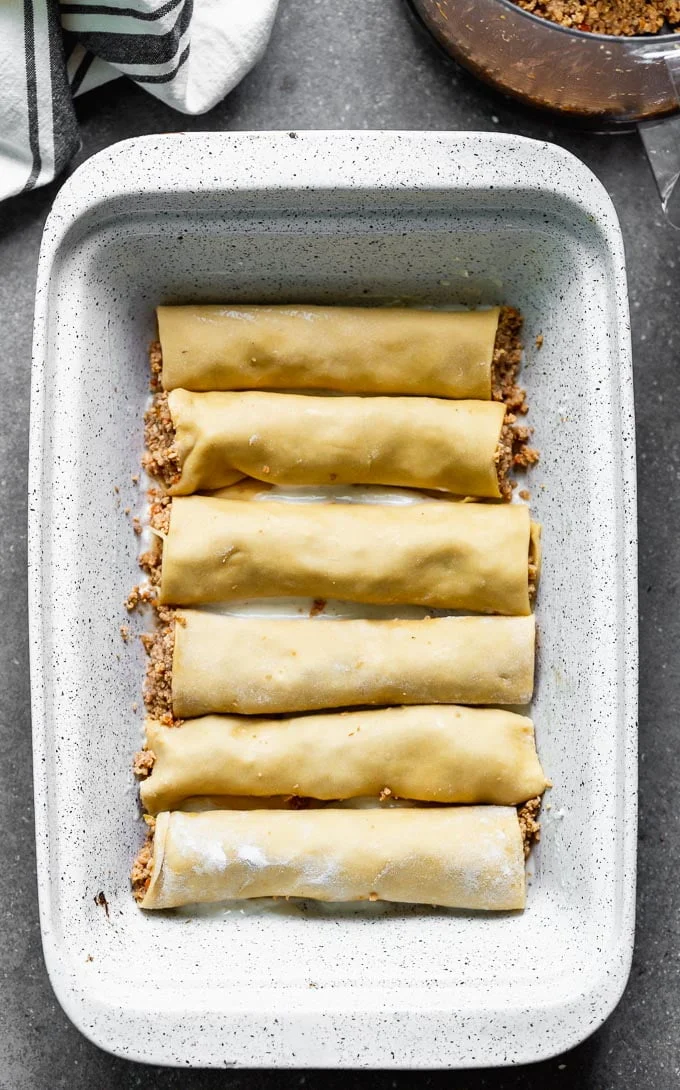 This Meat Cannelloni with Creamy Tomato Béchamel has homemade pasta is encased around a melt-in-your-mouth veal, pork, and chicken filling, it's covered in tomato sauce, creamy béchamel, and dusted with parmesan.