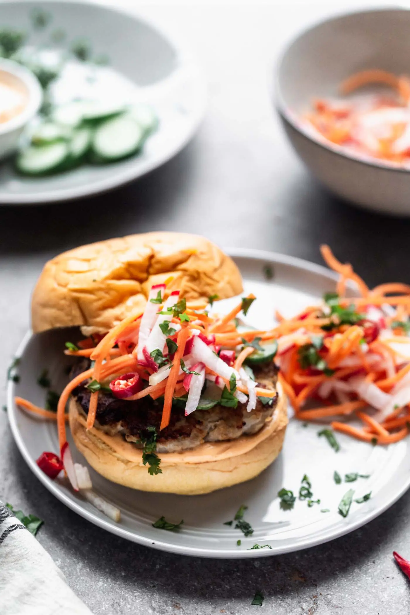 Bánh Mì Chicken Burgers are a burger take on a classic. A ground chicken patty is packed with all the flavors of a classic Bánh Mì sandwich, topped with sweet and spicy pickled veggies, a zippy sriracha mayo, and sandwiched between a toasted brioche bun. 