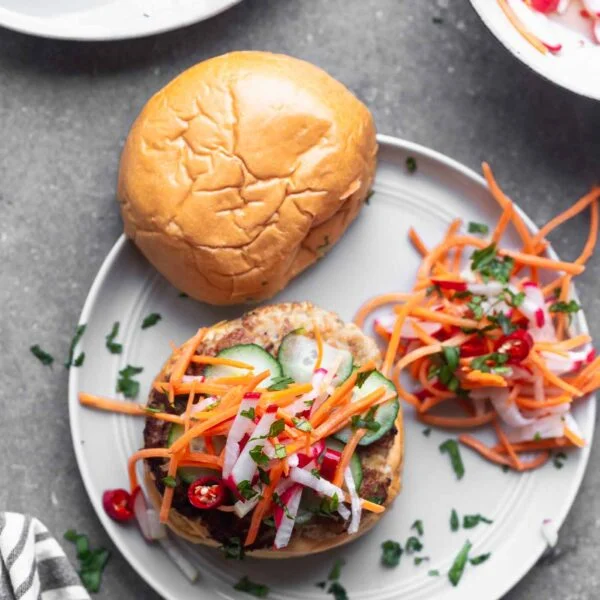 Bánh Mì Chicken Burgers are a burger take on a classic. A ground chicken patty is packed with all the flavors of a classic Bánh Mì sandwich, topped with sweet and spicy pickled veggies, a zippy sriracha mayo, and sandwiched between a toasted brioche bun.