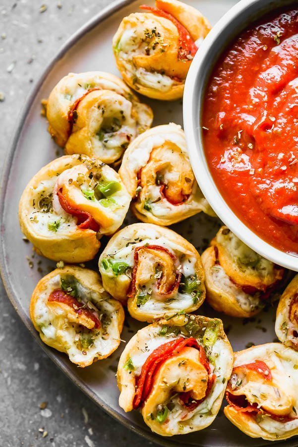 Supreme Pizza Pinwheel Poppers&nbsp;are the perfect Game Day appetizer! Store-bought crescent roll dough is wrapped around shredded mozzarella cheese, spicy pepperoni, and chopped green peppers. They're baked and then served with your favorite pizza sauce (or ranch!) for dipping.