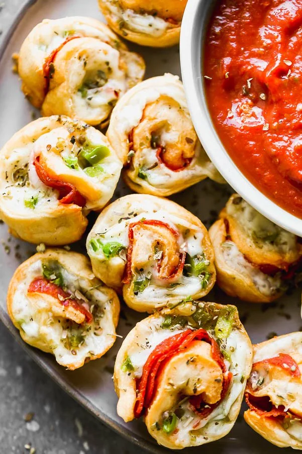 Supreme Pizza Pinwheel Poppers&nbsp;are the perfect Game Day appetizer! Store-bought crescent roll dough is wrapped around shredded mozzarella cheese, spicy pepperoni, and chopped green peppers. They're baked and then served with your favorite pizza sauce (or ranch!) for dipping.