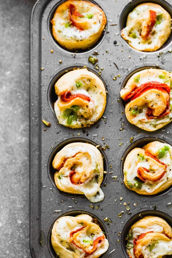 Supreme Pizza Pinwheel Poppers&nbsp;are the perfect Game Day appetizer! Store-bought crescent roll dough is wrapped around shredded mozzarella cheese, spicy pepperoni, and chopped green peppers. They're baked and then served with your favorite pizza sauce (or ranch!) for dipping.