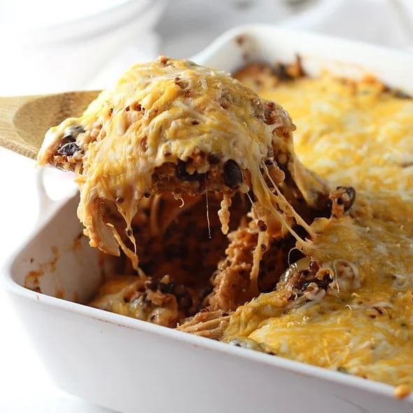 Healthy meets indulgent in this Quinoa Mexican Casserole. Cooked quinoa is mixed with a homemade enchilada sauce, black beans, chicken, and of course, plenty of cheese. It's popped into the oven until bubbly and hot, and it's ready to go! Easy to throw together, can be made ahead and a surefire win for family dinners.