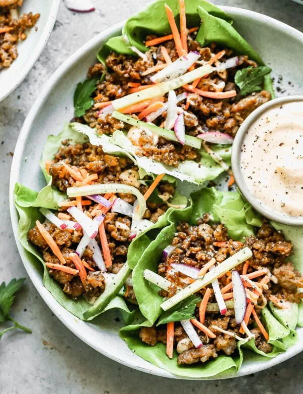 Let's take all of the flavors of a classic Banh Mi Sandwich deconstruct it and nestle everything into perfect little Vietnamese Lettuce Wraps. We will get crispy, salty ground pork, crisp veggies, with a sweet and spicy mayo drizzle in each drippy bite we take. And we will be happy. 