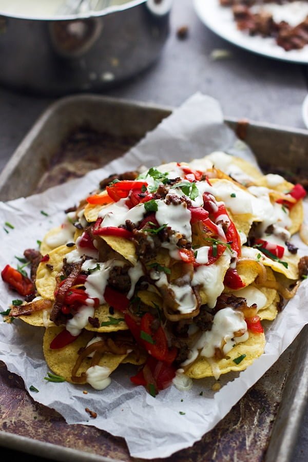 Italian Style Nachos - Layers of spicy italian sausage, roasted red peppers, fontina cheese and a creamy cheese sauce are the spin on a classic nacho!