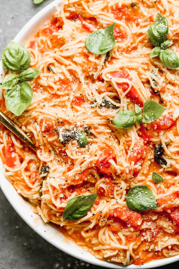 This One Pot Fresh Tomato Pasta is the perfect way to use up all your summer tomatoes! We cook down the tomatoes with an obscene amount of garlic, a little bit of sugar, and plenty of salt and then cook fresh pasta directly in the sauce. Finish it off with a handful of parmesan cheese, serve with a salad and this easy summer dinner is done. 