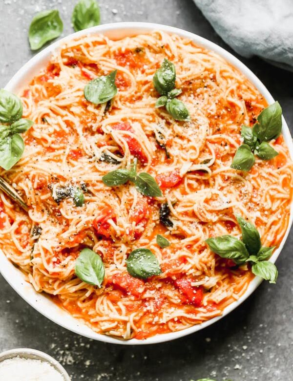 This One Pot Fresh Tomato Pasta is the perfect way to use up all your summer tomatoes! We cook down the tomatoes with an obscene amount of garlic, a little bit of sugar, and plenty of salt and then cook fresh pasta directly in the sauce. Finish it off with a handful of parmesan cheese, serve with a salad and this easy summer dinner is done. 
