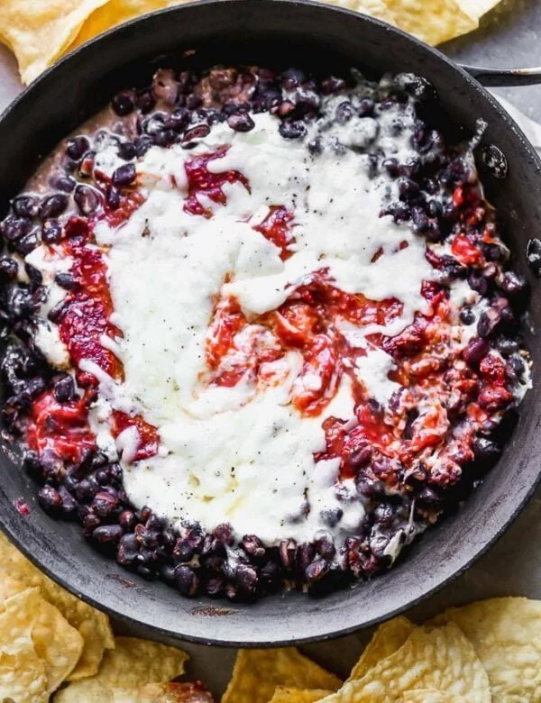 Chipotle Raspberry Black Bean Dip is sweet, spicy, and the most addictive appetizer on the planet. It's packed with a homemade raspberry chipotle sauce, tangy cream cheese, heart black beans, and gooey Monterrey jack cheese. Serve with tortilla chips and watch it disappear. 