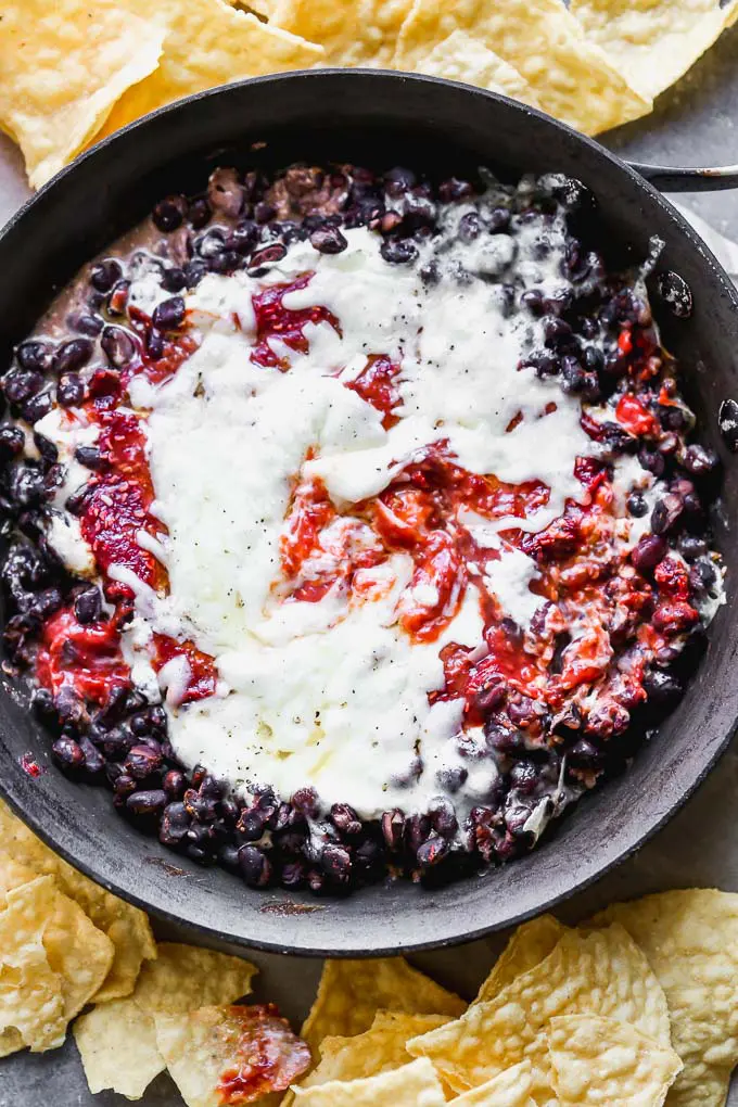 Chipotle Raspberry Black Bean Dip is sweet, spicy, and the most addictive appetizer on the planet. It's packed with a homemade raspberry chipotle sauce, tangy cream cheese, heart black beans, and gooey Monterrey jack cheese. Serve with tortilla chips and watch it disappear.&nbsp;