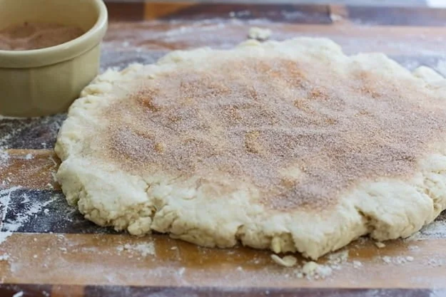 Cinnamon Roll Butterilk Biscuits - Super flaky layers of dough sprinkled with cinnamon and sugar and drenched in cream cheese frosting.