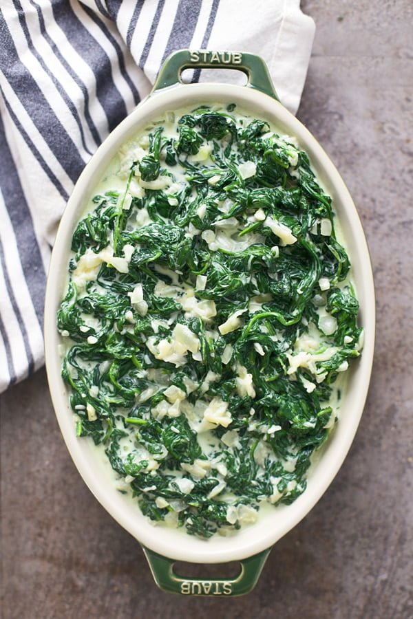 Transfer cheesy creamed spinach to prepared baking dish