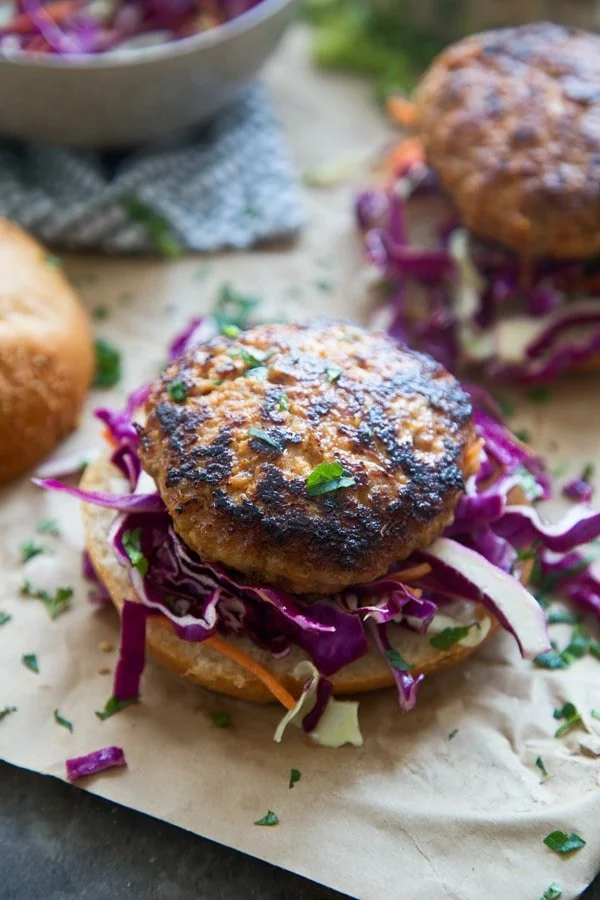 These Coconut Red Curry Burgers are irresistibly juicy on the inside, crispy on the outside and our new favorite way to eat a burger. The patties are also FULL of flavor, with hints of garlic, ginger, red chile paste and loads of coconut. Each crispy patty is topped with an super simple coconut curry sauce, lots of zippy slaw and nestled into a soft bun. 
