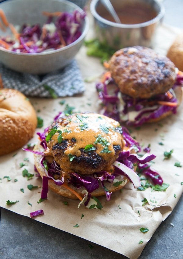 These Coconut Red Curry Burgers are irresistibly juicy on the inside, crispy on the outside and our new favorite way to eat a burger. The patties are also FULL of flavor, with hints of garlic, ginger, red chile paste and loads of coconut. Each crispy patty is topped with an super simple coconut curry sauce, lots of zippy&nbsp;slaw and nestled into a soft bun.&nbsp;