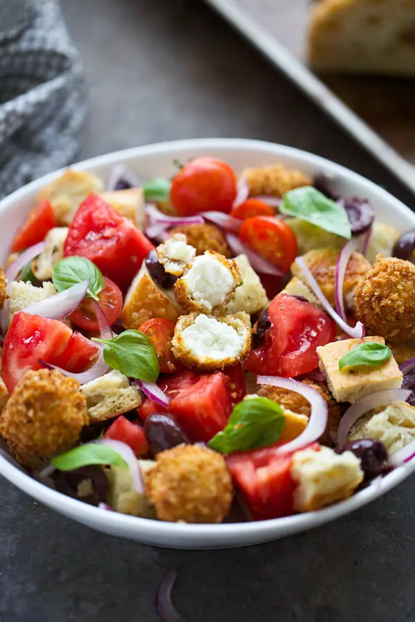 Bread salad with tomatoes, red onion, kalamata olives, basil, goat cheese and vinaigrette