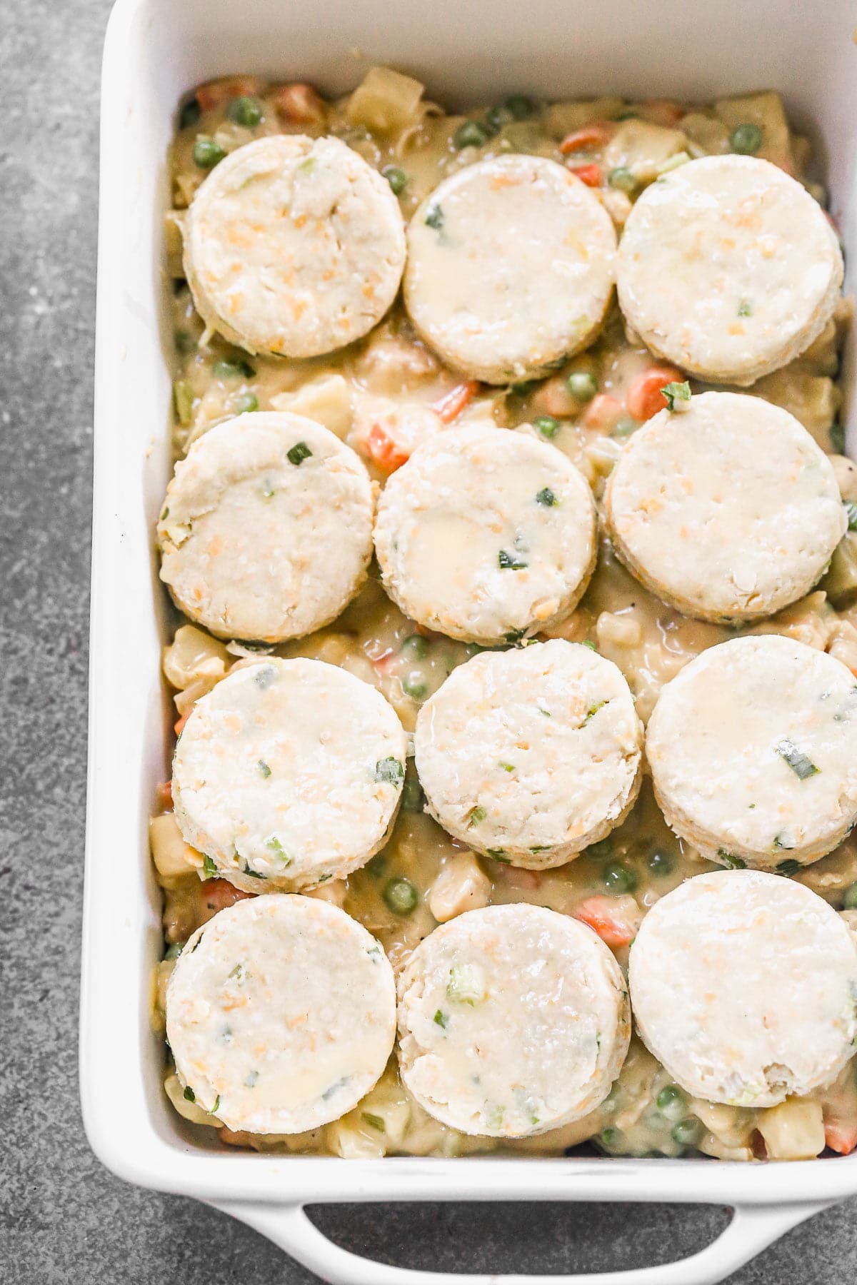Chicken Pot Pie topped with raw biscuits. 
