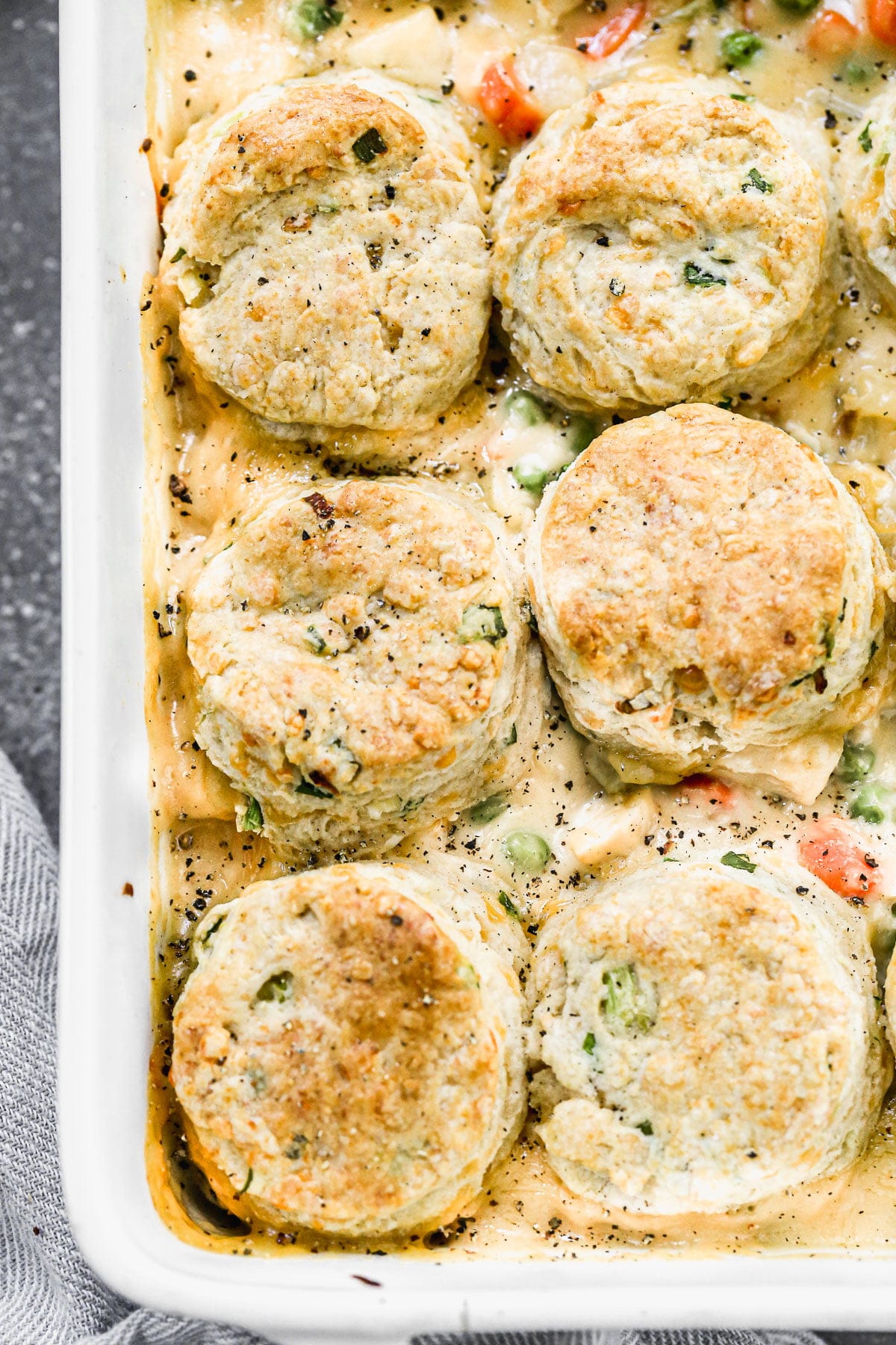 Possibly our&nbsp;favorite comfort food of fall, this&nbsp;Chicken Pot Pie with Biscuits is cozy, delicious and a such fun twist on traditional chicken pot pie. We take a classic creamy pot pie filling full of chicken, carrots, celery, and potatoes and stud it with sharp cheddar cheese and then&nbsp;top it off with fluffy, tender cheddar chive biscuits. Heaven in a casserole dish.