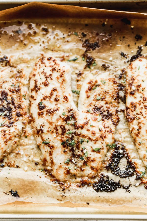 Parmesan Broiled Tilapia is one of our go-to meals because it requires minimal ingredients, all of of which you likely have in your pantry, and takes less than 30 minutes to whip up, from start to finish. We take flaky tilapia filets and&nbsp;smother them in a butter and parmesan paste laced with hot sauce, then pop them under the broiler until they have an&nbsp;irresistible golden crust. &nbsp;