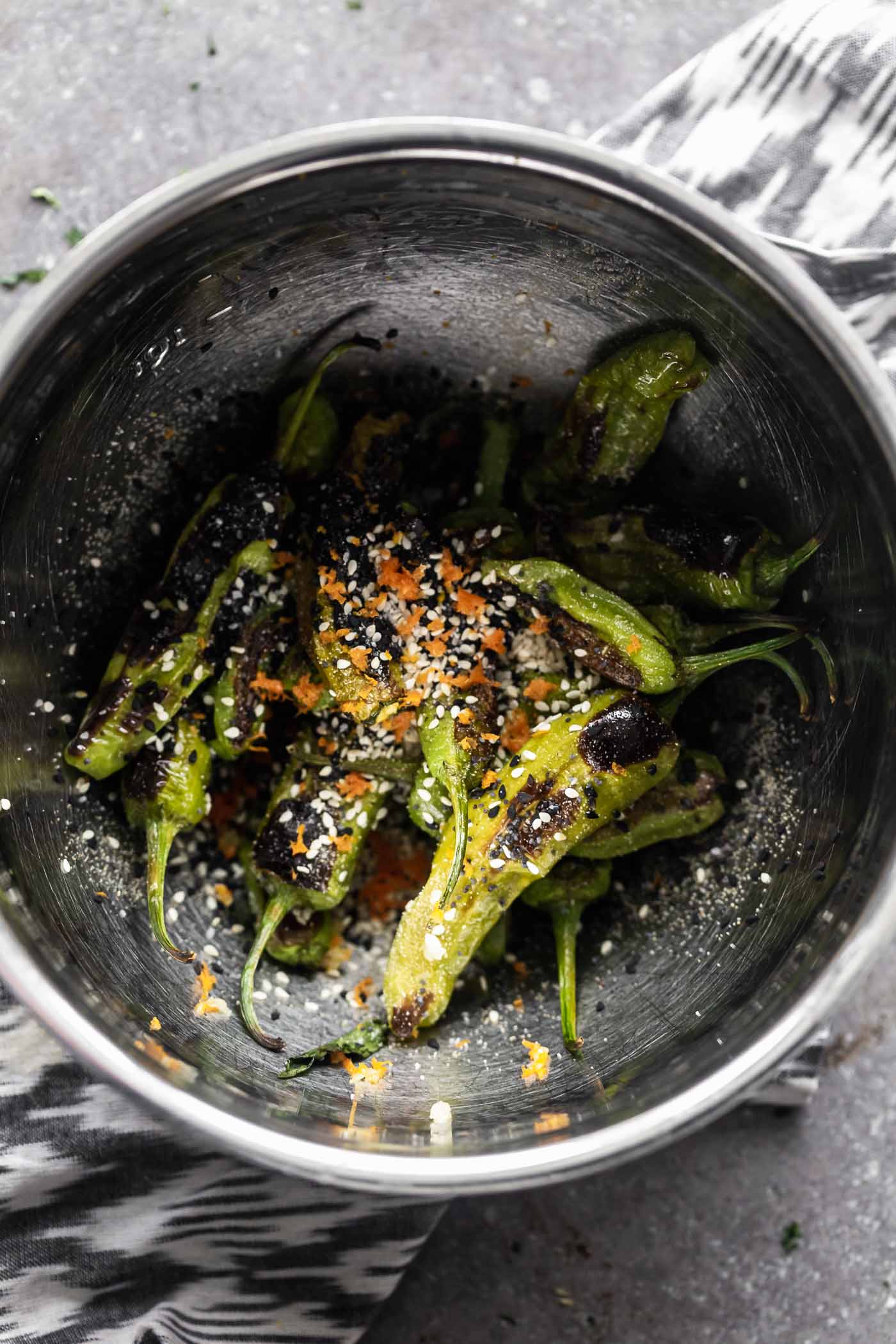 These Roasted Shishito Peppers with Soy Glaze are the perfect blend of sweet, spicy and savory. Each pepper is charred under the broiler, then tossed in an easy soy-based glaze, sesame seeds and a little bit of orange peel. The perfect snack!