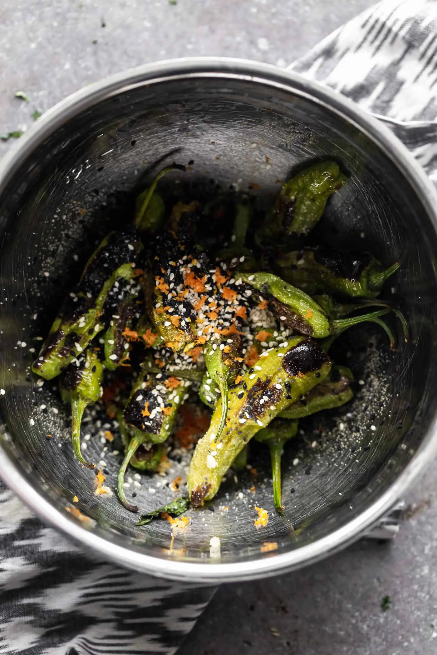 These Roasted Shishito Peppers with Soy Glaze are the perfect blend of sweet, spicy and savory. Each pepper is charred under the broiler, then tossed in an easy soy-based glaze, sesame seeds and a little bit of orange peel. The perfect snack!