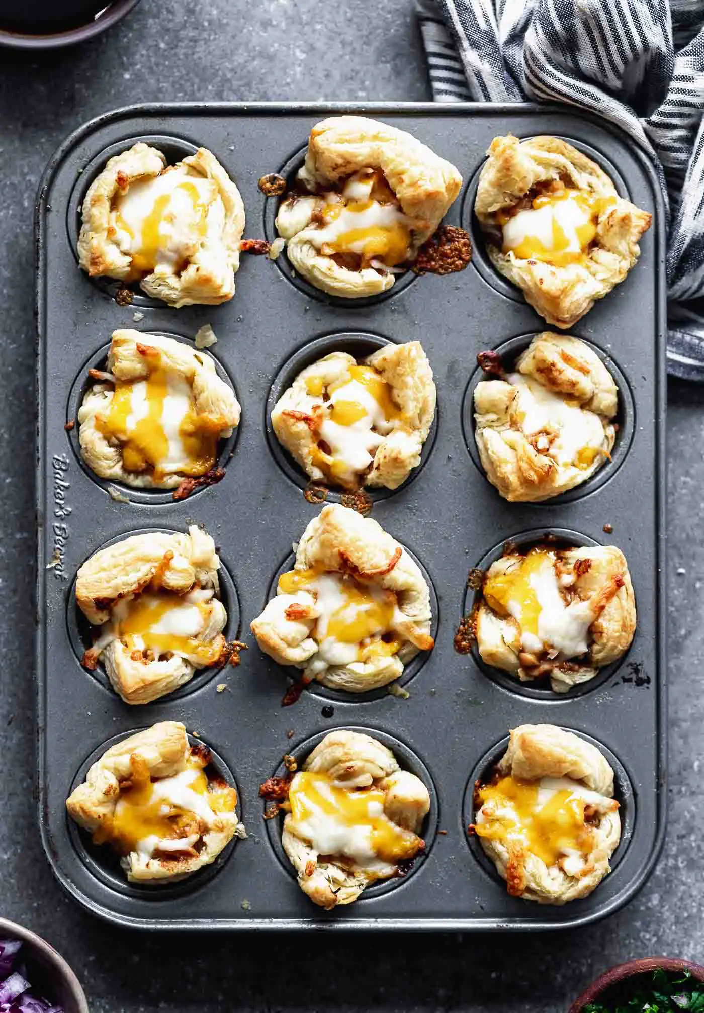 Cheesy Barbecue Chicken Bites: Chopped chicken tossed in your favorite barbecue sauce, covered in cheese and served with chopped red onion and cilantro. The perfect bite-sized appetizer for a crowd!