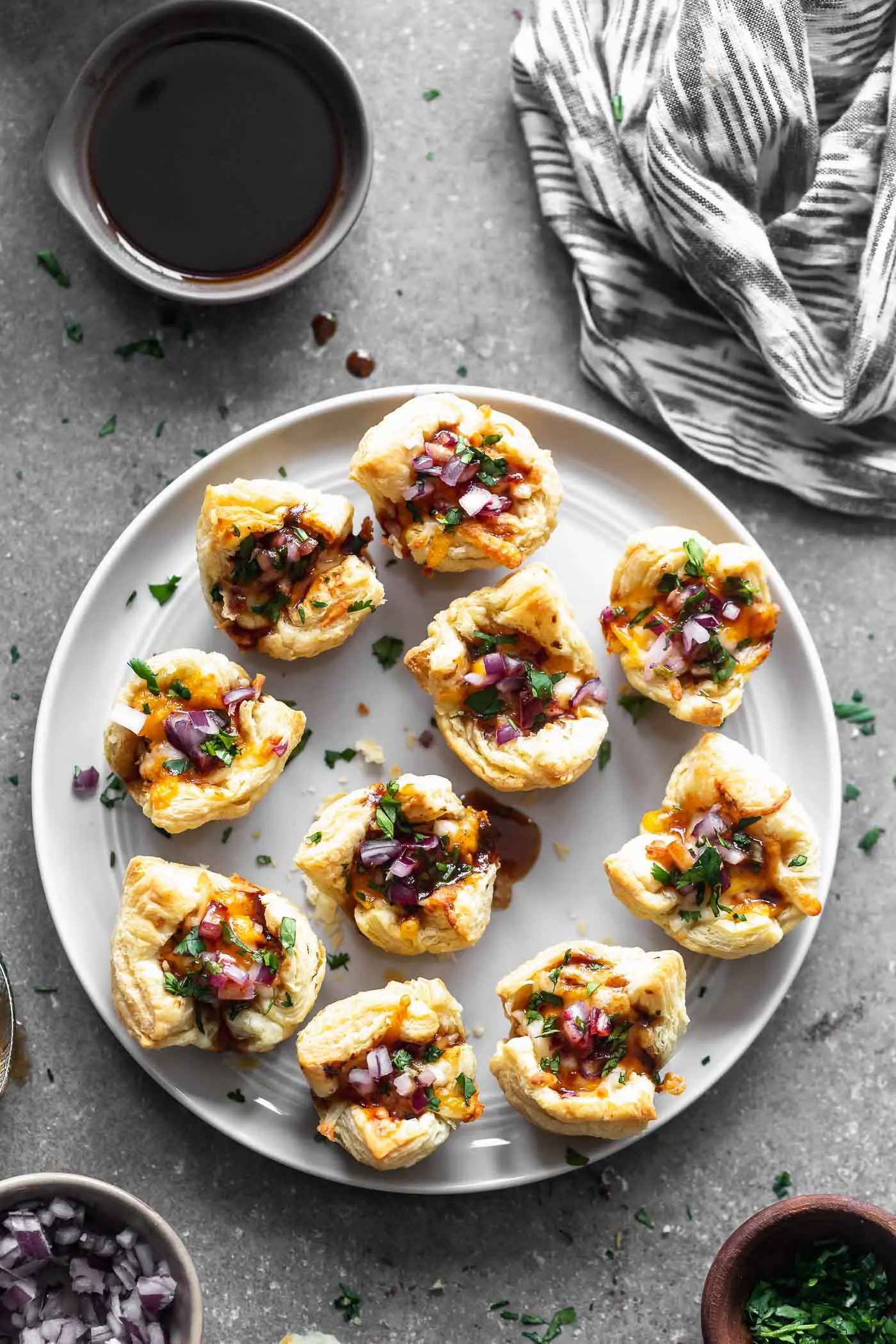 Cheesy Barbecue Chicken Bites: Chopped chicken tossed in your favorite barbecue sauce, covered in cheese and served with chopped red onion and cilantro. The perfect bite-sized appetizer for a crowd!