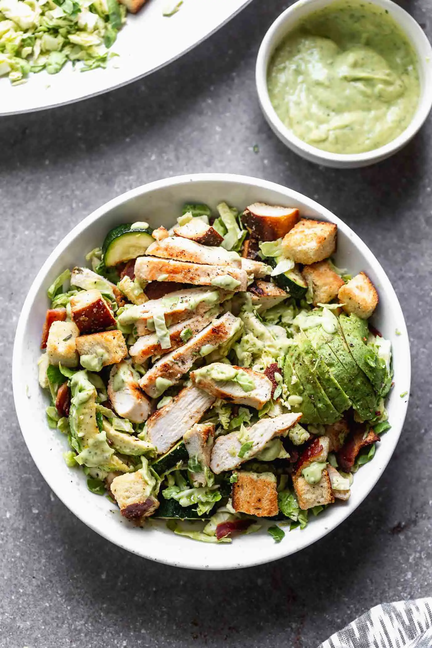 Our Brussels Sprout Green Goddess Salad with Bacon and Grilled&nbsp;Chicken is hearty, healthy, and one of the best salads you'll ever make. We toss shredded&nbsp;Brussels sprouts with grilled zucchini, grilled chicken, crispy bacon, and crunch&nbsp;croutons and then toss everything in an herb-packed dressing you'll want to smother on EVERYTHING.&nbsp;
