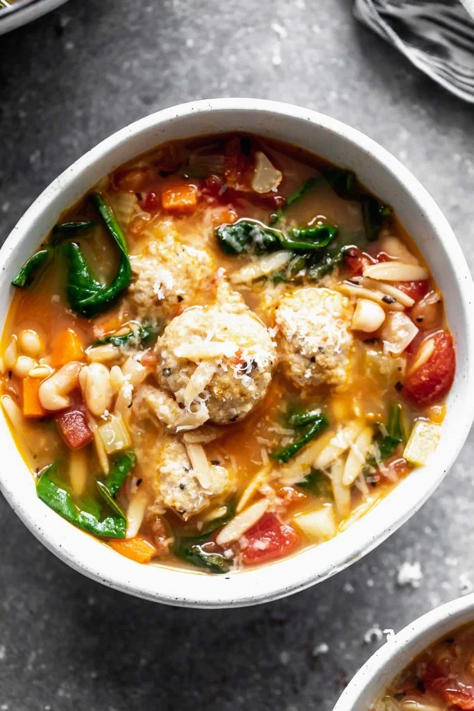 Minestrone with Chicken Meatballs is a hybrid of two comforting soups - minestrone and Italian wedding soup. With a rich, parmesan-infused broth, tons of veggies, whole-wheat orzo, and the most tender, flavorful chicken meatballs, this is a healthy winter soup worth making over and over again.