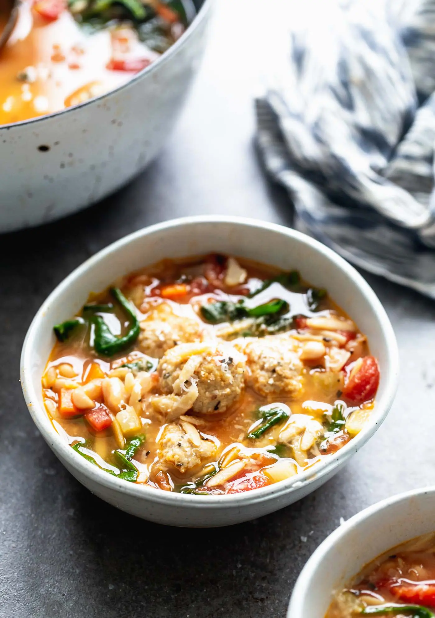 Minestrone with Chicken Meatballs is a hybrid of two comforting soups - minestrone and Italian wedding soup. With a rich, parmesan-infused broth, tons of veggies, whole-wheat orzo, and the most tender, flavorful chicken meatballs, this is a healthy winter soup worth making over and over again.
