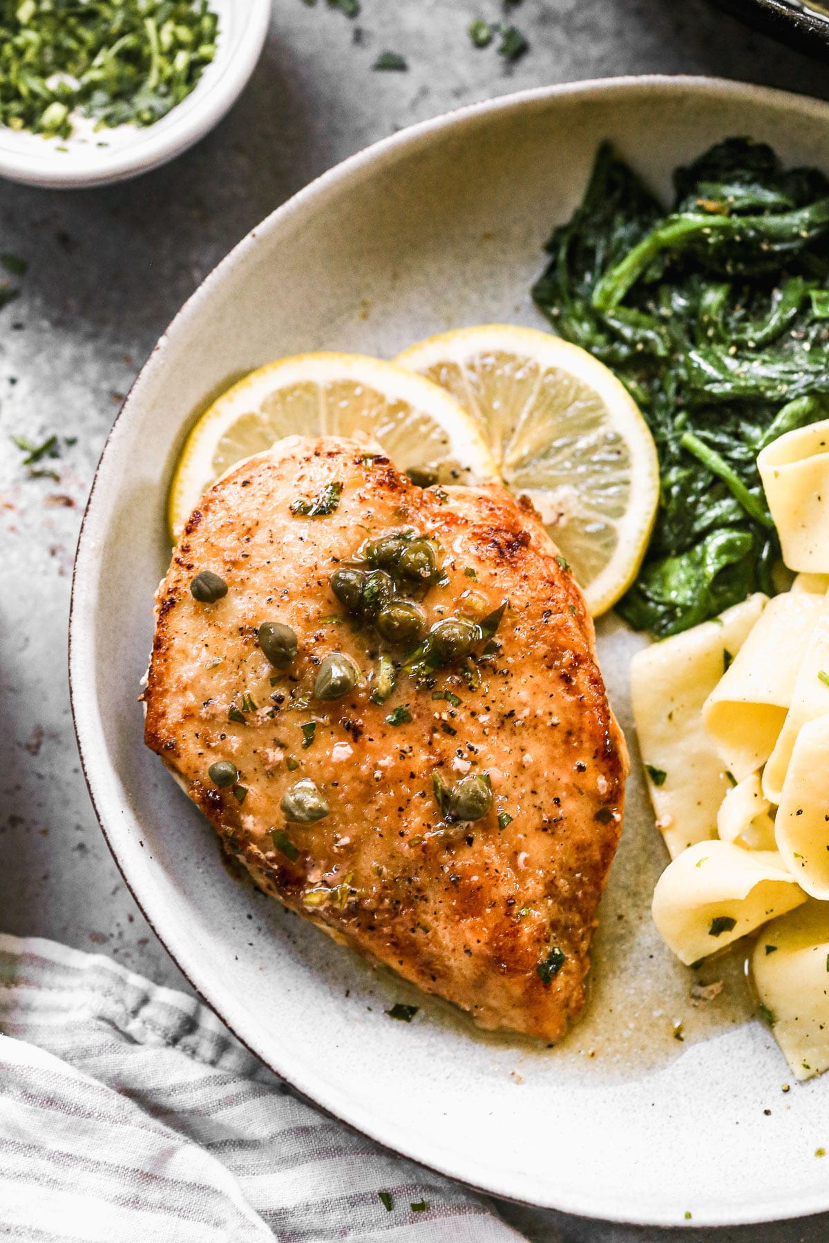 This Healthy Chicken Piccata Recipe&nbsp;will quickly become your new favorite weeknight dinner! Thin chicken breasts are sautéed in butter until crusty and golden brown, then smothered in a zippy lemon and white wine butter sauce. Easy, light and so delicious!&nbsp;