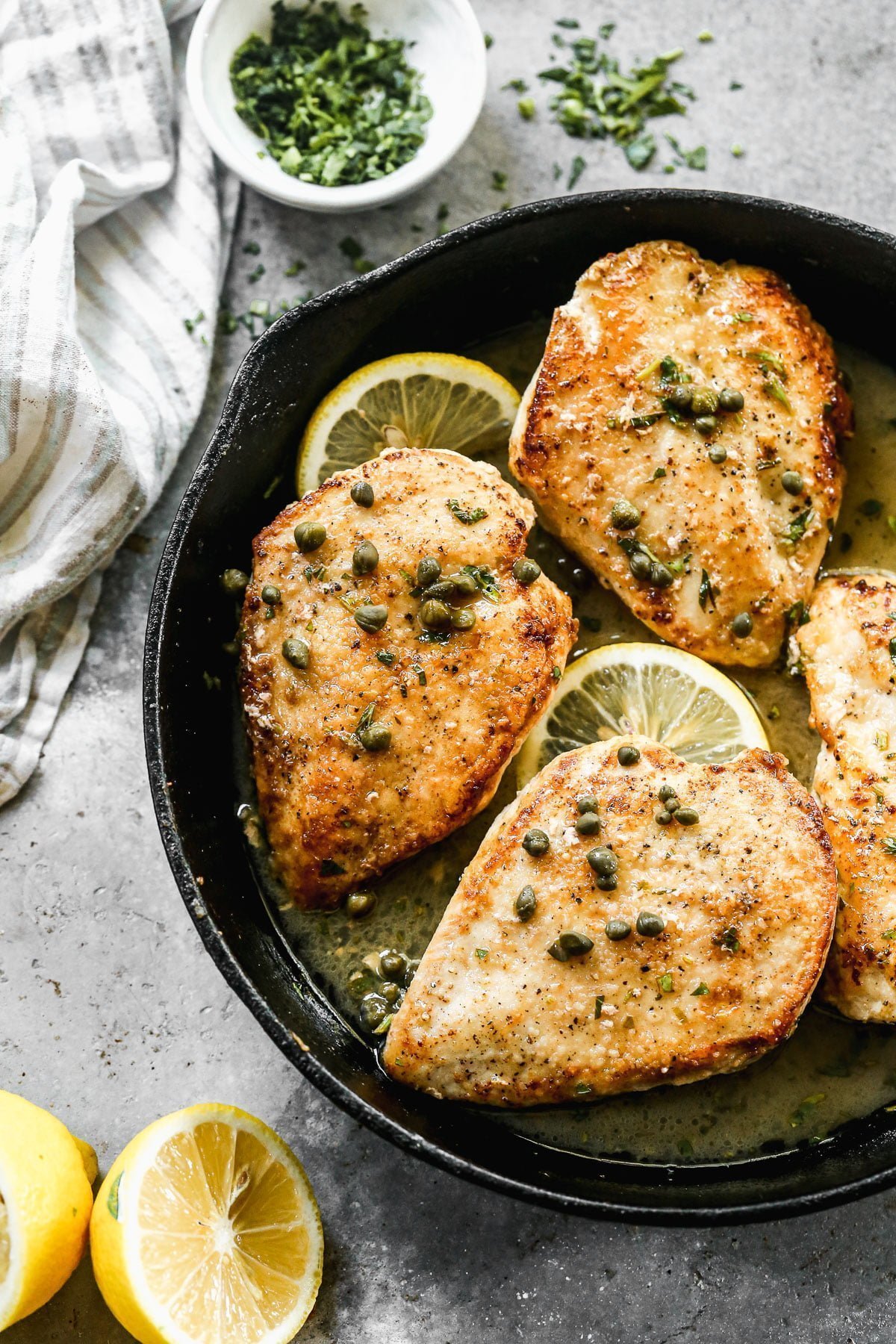 This Healthy Chicken Piccata Recipe will quickly become your new favorite weeknight dinner! Thin chicken breasts are sautéed in butter until crusty and golden brown, then smothered in a zippy lemon and white wine butter sauce. Easy, light and so delicious! 