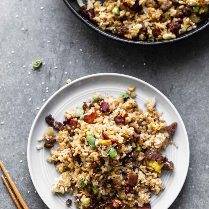 This Breakfast Fried Rice Recipe is packed with salty bacon and sausage, a light soy sauce, oniob, garlic, and plenty of hearty scrambled eggs.