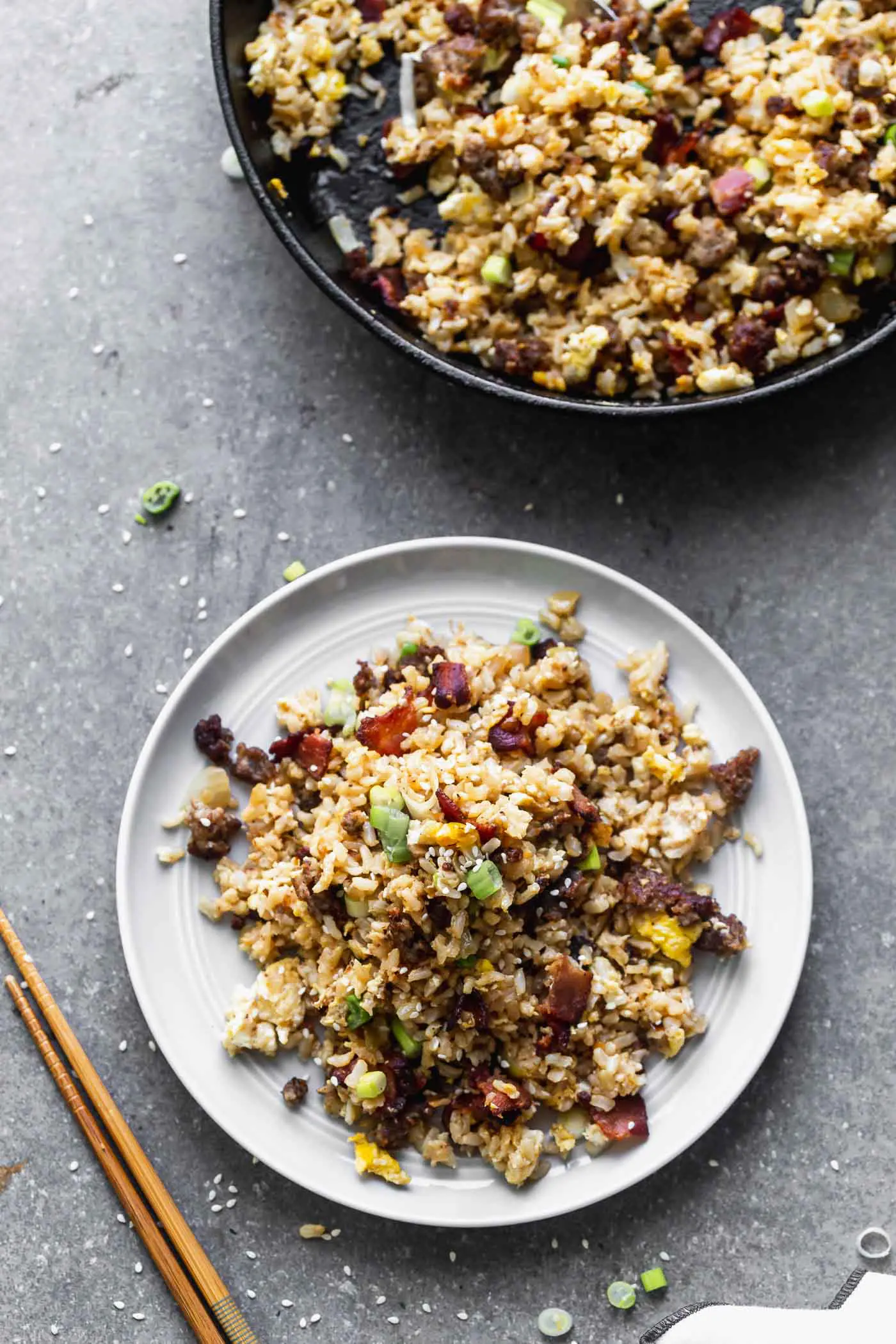 This Breakfast Fried Rice Recipe is packed with salty bacon and sausage, a light soy sauce, oniob, garlic, and plenty of hearty scrambled eggs.