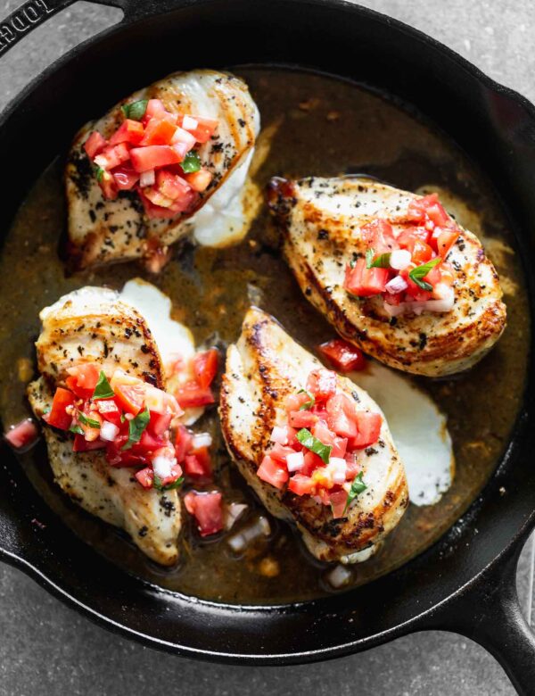 This Cheesy Lemon Chicken with Bruschetta Topping is stuffed with gooey mozzarella cheese, served with an easy pan sauce, and a fresh tomato topping.
