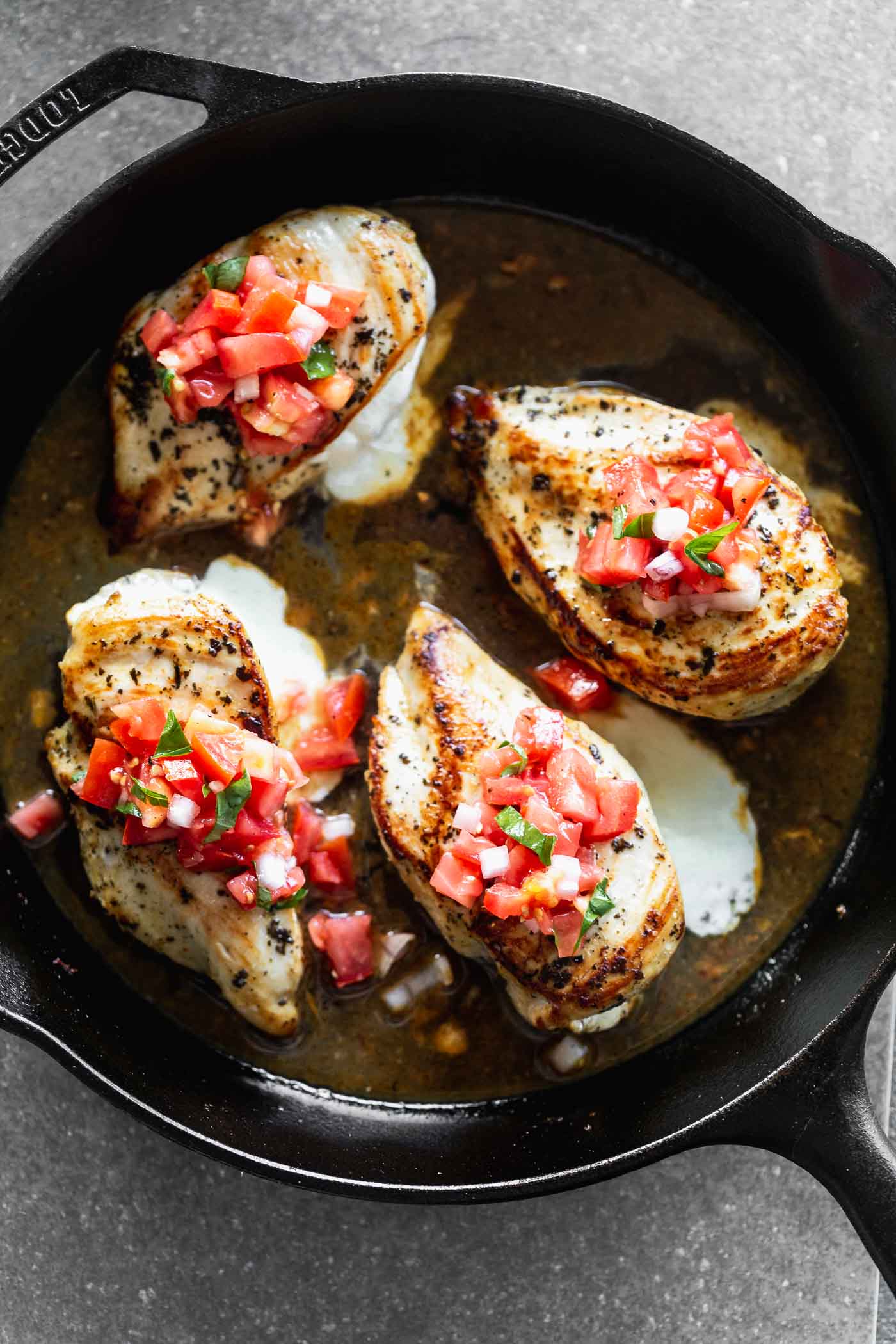 This Cheesy Lemon Chicken with Bruschetta Topping is stuffed with gooey mozzarella cheese, served with an easy pan sauce, and a fresh tomato topping.