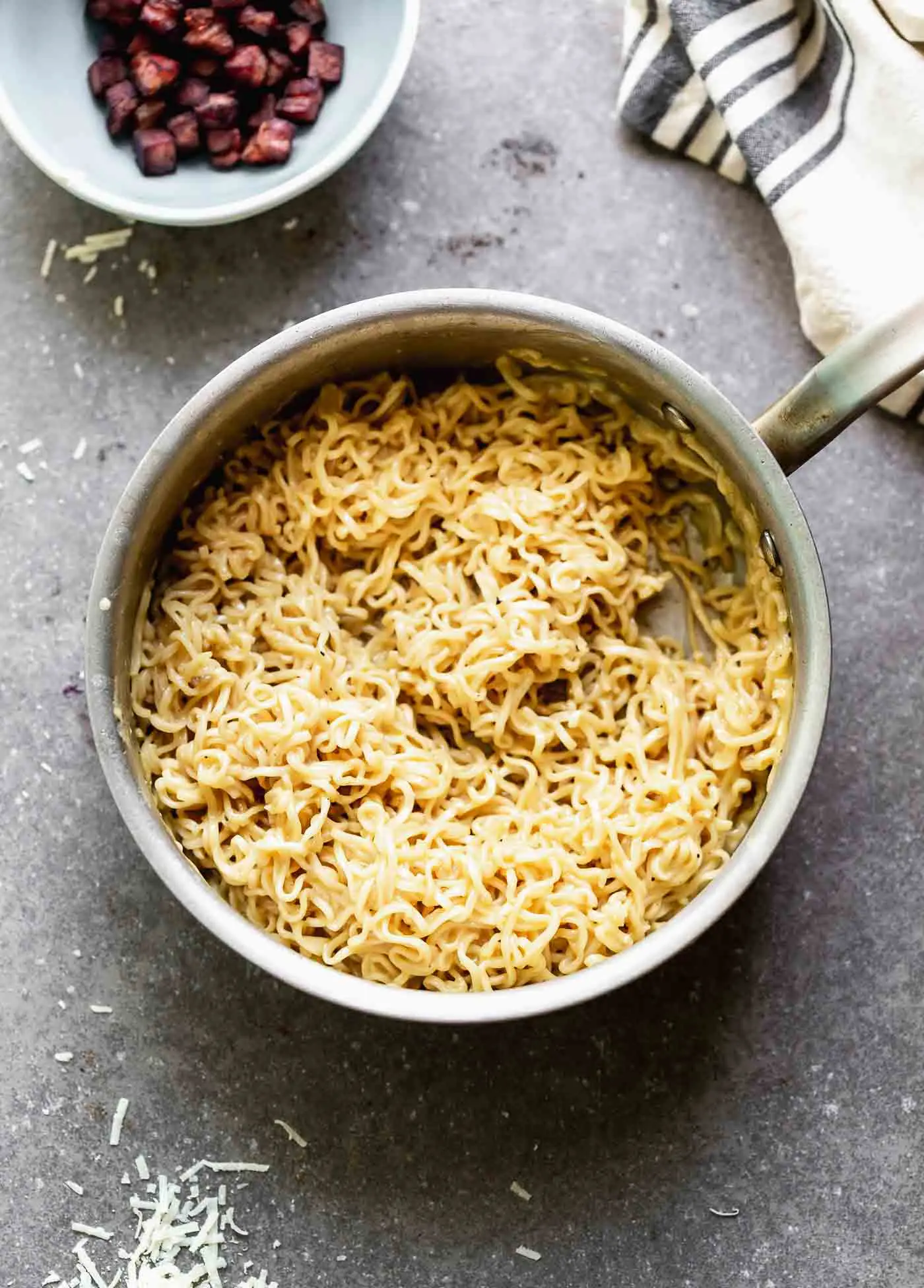 Tossing ramen noodles with carbonara sauce