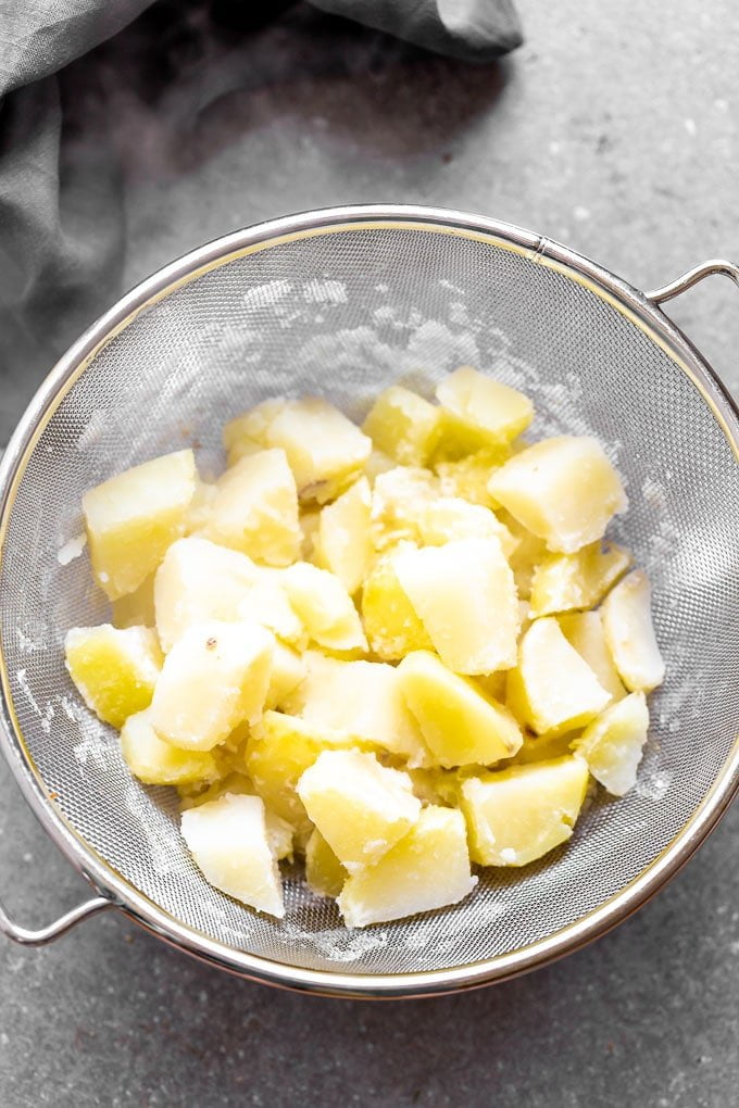 Boil potatoes and let them drip of all excess moisture.