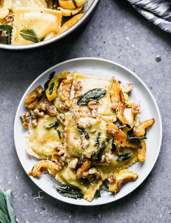 Ravioli with Brown Butter takes a simple store-bought ravioli and transforms it into a stunning dish perfect for a special occasion. This is packed with creamy sausage and ricotta-stuffed ravioli, an intoxicatingly nutty brown butter sauce, fried sage leaves, sweet roasted delicata squash, and crunchy walnuts. It's the perfect fall meal. 