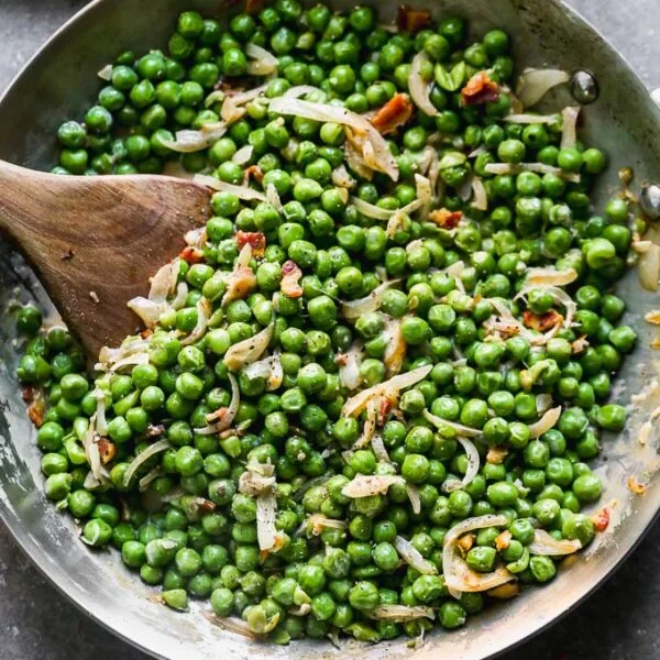 Creamy Peas and Pancetta look simple, but I assure you, there's ample flavor intertwined between those crisp, sweet peas and crispy pancetta. The peas are coated in a sweet and salty sherry-infused cream sauce and lots of caramelized shallots. They're the perfect way to make an easy side dish just a little bit more elevated than your average batch of buttered peas. 
