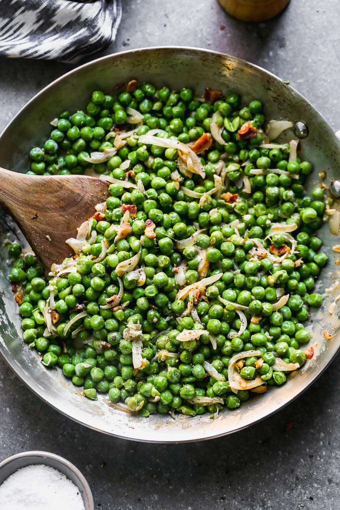 Creamy Peas and Pancetta look simple, but I assure you, there's ample flavor intertwined between those crisp, sweet peas and crispy pancetta. The peas are coated in a sweet and salty sherry-infused cream sauce and lots of caramelized shallots. They're the perfect way to make an easy side dish just a little bit more elevated than your average batch of buttered peas.&nbsp;