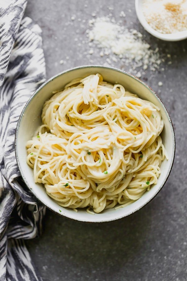 This One Pot Garlic Parmesan Pasta is creamy, slightly cheesy, and so darn good. Angel hair pasta is cooked in a mixture of chicken broth and milk until the pasta is perfectly aldente and swimming in a creamy sauce. It