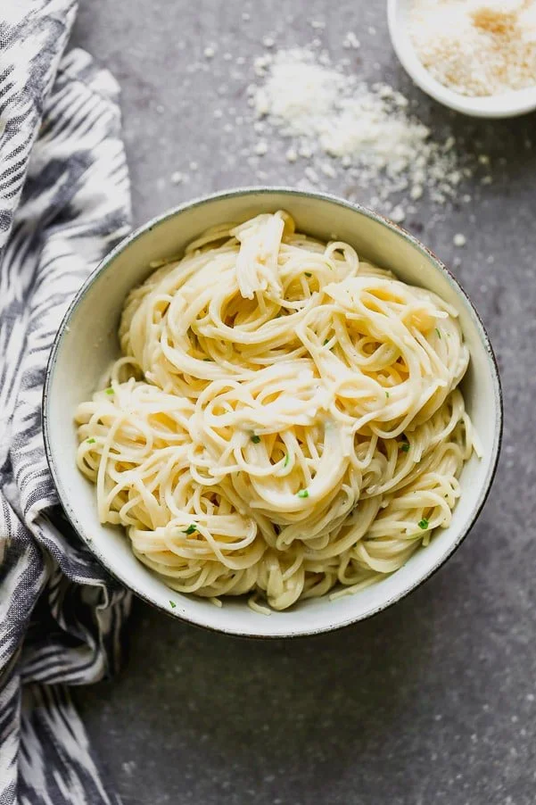 This One Pot Garlic Parmesan Pasta is creamy, slightly cheesy, and so darn good. Angel hair pasta is cooked in a mixture of chicken broth and milk until the pasta is perfectly aldente and swimming in a creamy sauce. It's laced with the perfect amount of parmesan, a tiny bit of butter and plenty of fresh parsley. Perfect to serve as a side or alongside chicken or shrimp for a full meal.&nbsp;