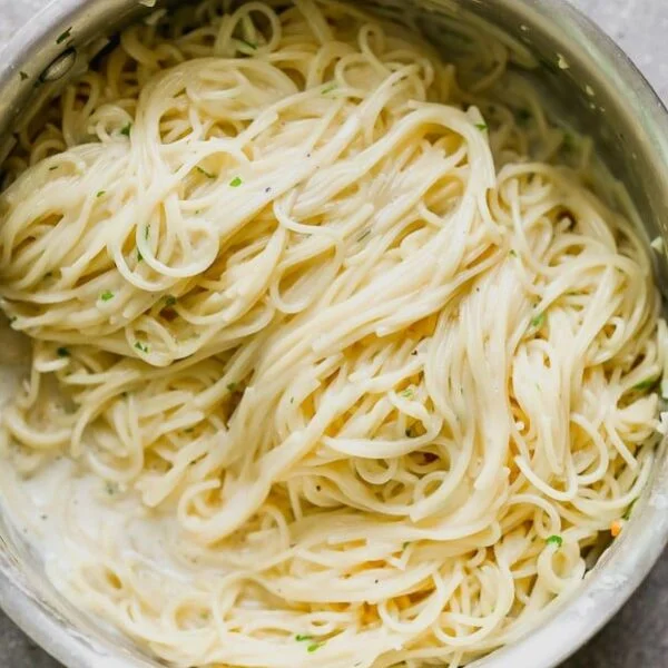 This One Pot Garlic Parmesan Pasta is creamy, slightly cheesy, and so darn good. Angel hair pasta is cooked in a mixture of chicken broth and milk until the pasta is perfectly aldente and swimming in a creamy sauce. It's laced with the perfect amount of parmesan, a tiny bit of butter and plenty of fresh parsley. Perfect to serve as a side or alongside chicken or shrimp for a full meal. 