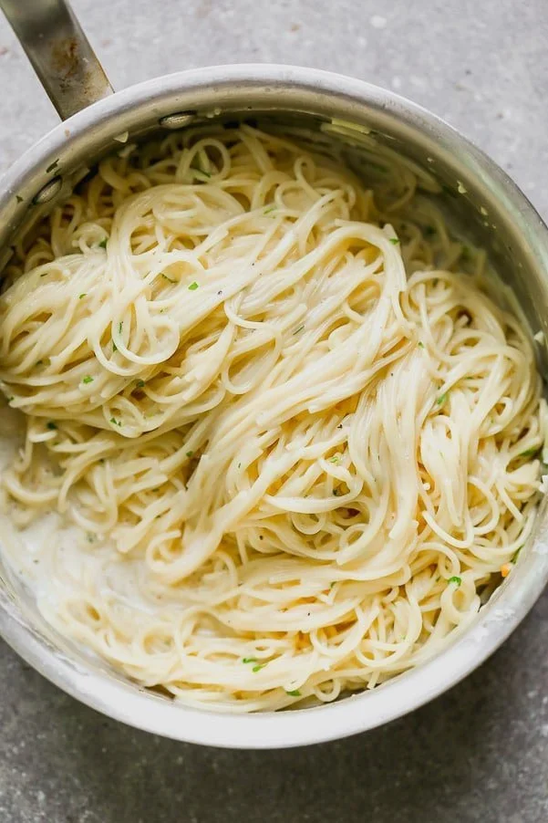 This One Pot Garlic Parmesan Pasta is creamy, slightly cheesy, and so darn good. Angel hair pasta is cooked in a mixture of chicken broth and milk until the pasta is perfectly aldente and swimming in a creamy sauce. It's laced with the perfect amount of parmesan, a tiny bit of butter and plenty of fresh parsley. Perfect to serve as a side or alongside chicken or shrimp for a full meal.&nbsp;