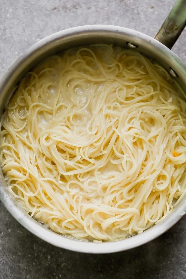 Simmer angel hair in chicken broth, milk, and garlic