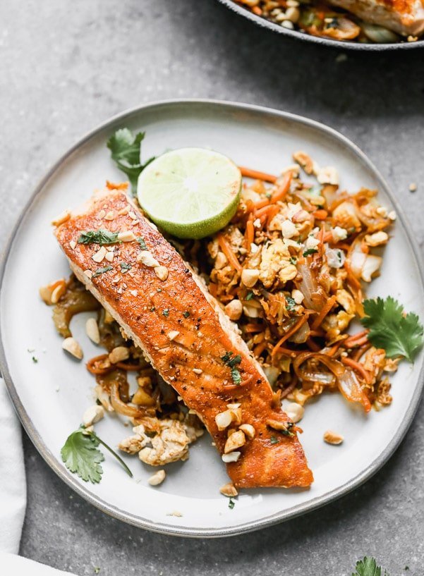 Pad Thai Salmon has all of the flavors of a classic pad Thai, but skips the noodles in lieu of sautéed veggies nestled beneath a crispy filet of salmon. Quick, easy, and healthy! &nbsp;