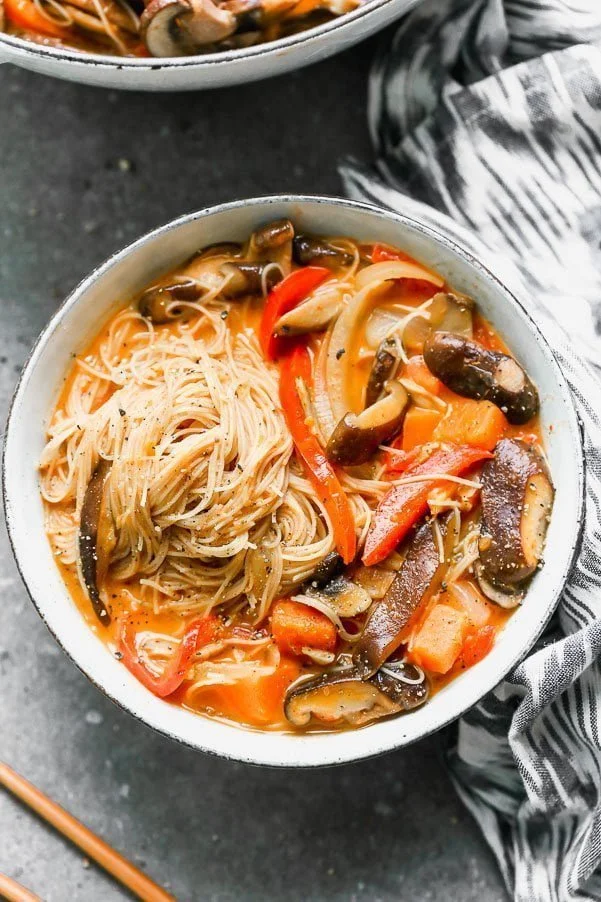 Vegetable Coconut Curry Soup with Rice Noodles is sweet, slightly spicy, and a cinch to throw together. It's packed with tender mushrooms, red bell peppers, onion, and the most delicious coconut curry broth you'll want to drink. It's served with plenty of thin brown rice noodles to slurp!&nbsp;