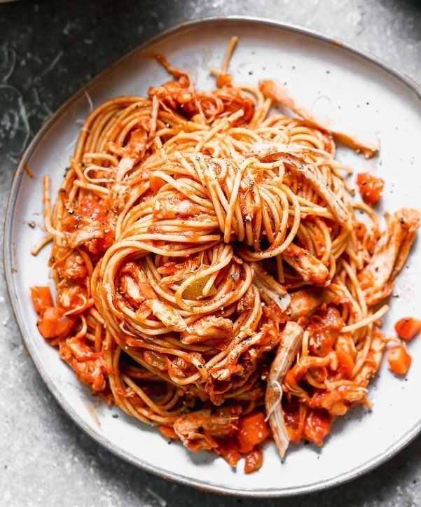 This healthy Chicken Bolognese uses chicken thighs that are slow-cooked in a red wine and a vegatable tomato sauce and tossed with whole-wheat spaghetti.