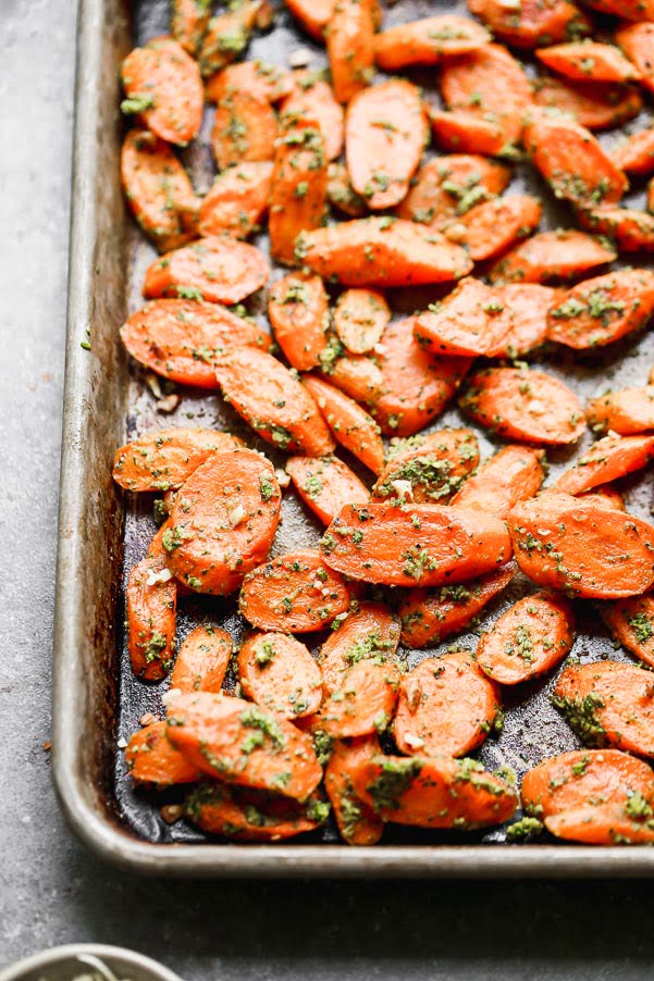 These Easy Roasted Carrots with Pecan Pesto are the perfect side dish for all your spring meals. Fresh spring carrots are roasted until soft and sweet and then tossed in a super easy pecan and spinach pesto. This recipe yields a large amount, so you’ll have plenty of leftovers to pull out during the week.