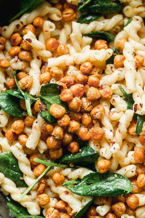 Pasta e Ceci Alla Romana (Pasta with Chickpeas) is a light, hearty, and healthy pasta dish. Aldente gemelli pasta is tossed with garlic, lemon, plenty of crushed red pepper flakes and just enough starchy pasta water to make a light sauce. It's also packed with crispy chickpeas, sweet roasted garlic and tender spinach leaves. 